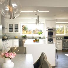 White Modern Eat-in Kitchen With Large Island and Funky Lighting