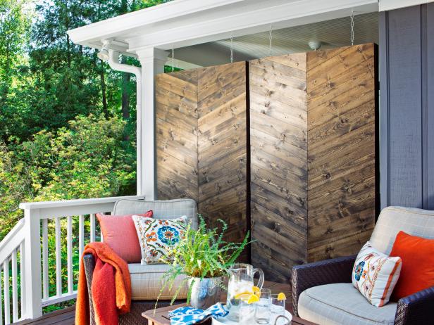 Wooden privacy screens section off this rustic porch sitting area. The modern herringbone design creates a stylish twist on a basic door.