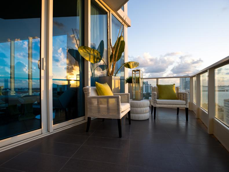 Terrace With White Outdoor Chairs, End Table and White & Glass Railing