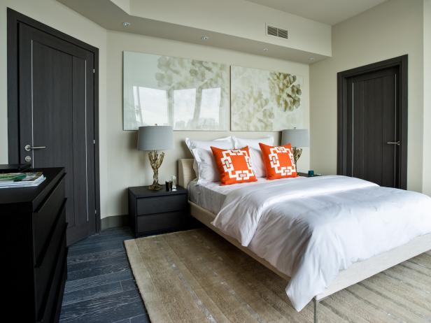 A modern guest suite with white linens and dark wood.