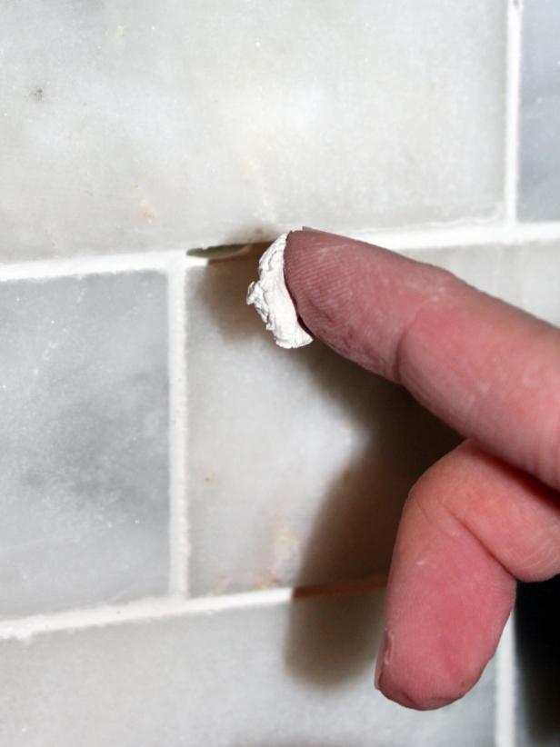 As you clean the tile, look at the backsplash from all angles to check for gaps in the grout. Just fill any in with a dab of grout on your fingertip, and use the sponge to clean off any excess,