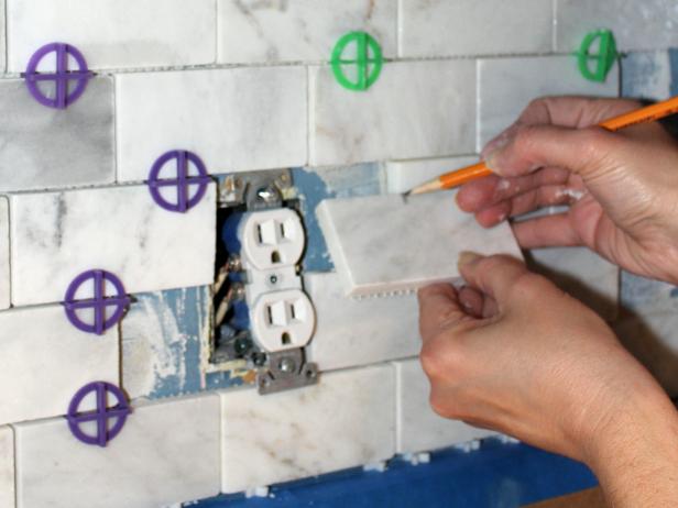 Make cutting tiles simple by holding a whole tile in front of the area you need to cover and making a light pencil mark where you need to cut.
