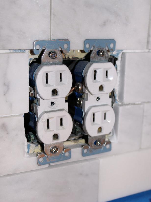 Marble is delicate. If you force the tile through too quickly, your cut will not be smooth. Back-butter and position your cut tiles around outlet, sliding them under the outlet's metal clips.