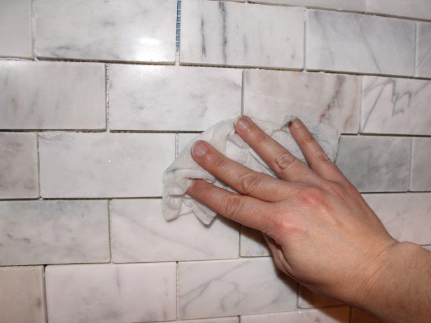 Once mortar has cured and spacers are removed, use damp paper towels to meticulously clean surface of tile to remove any bits of mortar or dust.