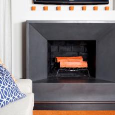 Sleek Gray Fireplace Boasts Bold Orange Accents