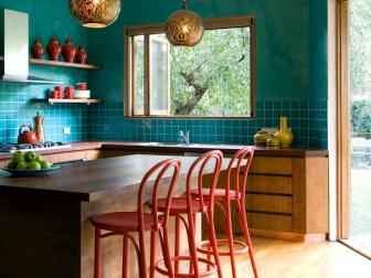 Eat-In Kitchen With Blue Tile Backsplash, Gold Light and Red Barstools