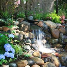 Backyard River Rock Waterfall With Blue Hydrangea