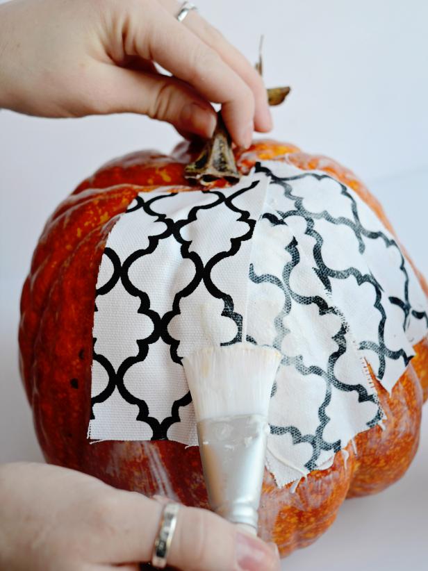 Place a new fabric strip on pumpkin, overlapping last strip. Continue this process until entire pumpkin is covered in fabric. Trim smaller pieces of fabric if necessary. Hang pumpkin from stem or elevate on a metal can to dry. Tip: Pumpkins with a smooth texture and shallow ridges are best for this project.
