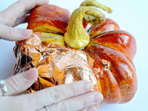 Apply metallic leaf over a pumpkin for fun fall decoration. Working from the top of the pumpkin down, gently apply full sheets of desired metallic leaf to entire surface of pumpkin, except stem.