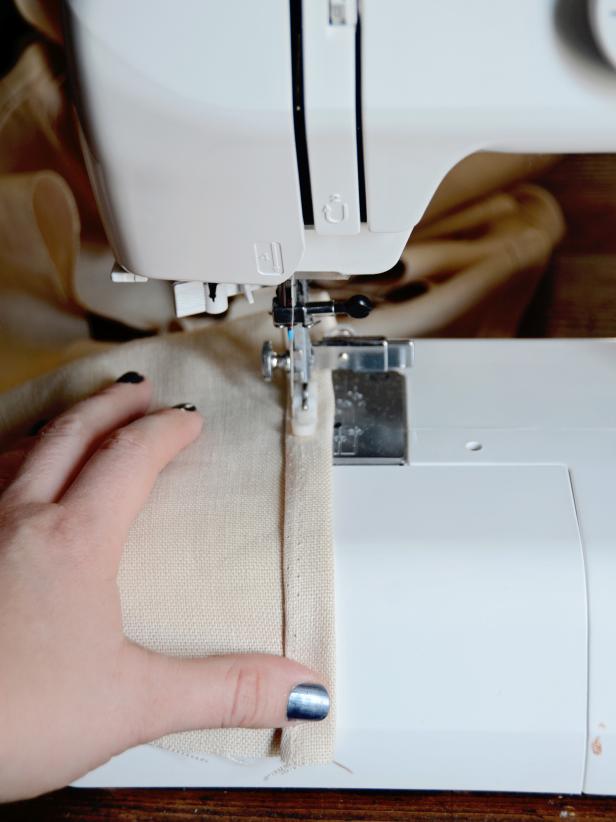 Once there is one long strip of fabric, hem one edge by folding it under 1/4-inch then again 1/2-inch and sew along fold. Tip: To make the hem super sharp, iron the folds and pin down prior to sewing.