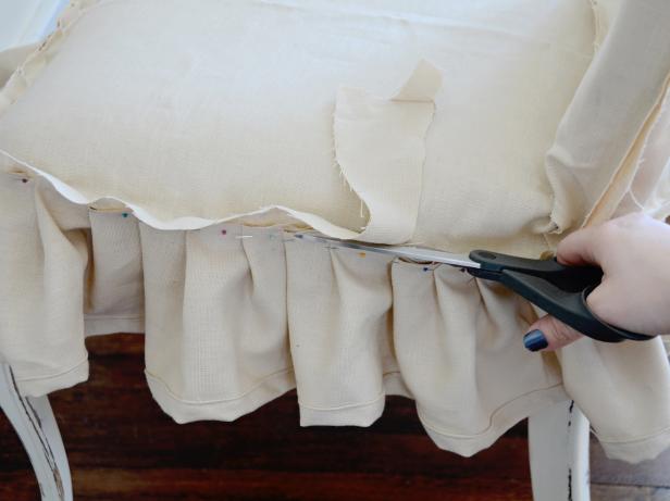 Trim excess fabric and sew skirt and seam. Remove pins then iron slipcover, especially the skirt, so it lies flat. Wash and iron as needed. Tip: Add piping along skirt and chair back or ribbon ties or buttons along the back to further customize your slipcover.