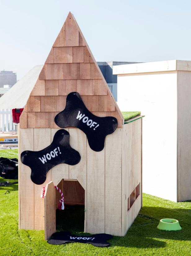 Wood Dog House With Shingled Roof and Black Dog Bones on Exterior