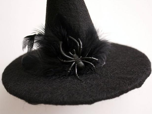 Once you've glued the felt cone to the felted cardboard, add black feathers and spider and glue in place.