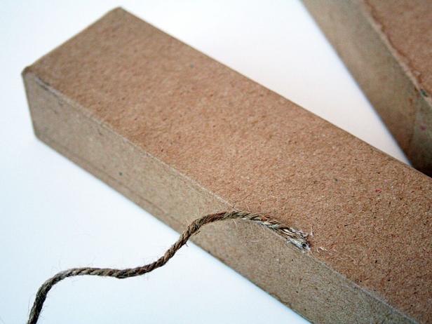 Start by securing the jute on the back side of the letter with a glue gun. You'll eventually wrap the entire letter, horizontally.
