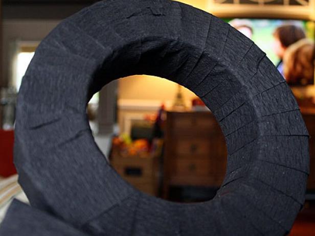 Begin by wrapping the foam wreath with the black crepe paper (you can also use paper streamers, ribbon or fabric).