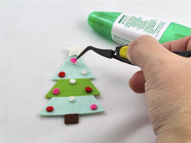 Glue the ornaments to the felt tree using tweezers to hold the tiny pieces.