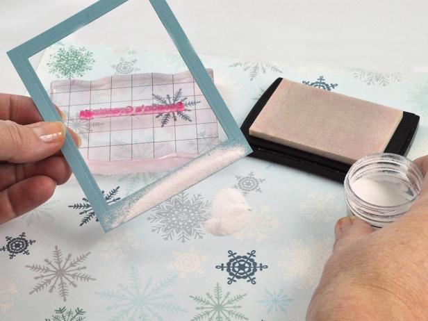 Tap off excess embossing powder from the frame of the snow shaker holiday card.