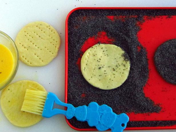 Brush the rounds of dough on one side and all around the edge with egg wash. Set the egg washed side of the dough into the poppy seeds and press gently. Be sure to press poppy seeds all around the edge of the dough, as well.