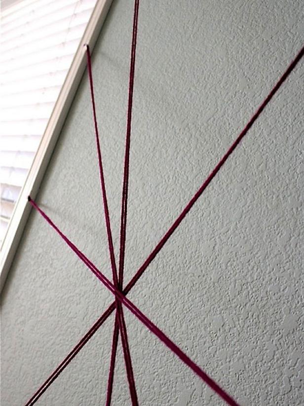 Make an X, then make other crisscross lines, and finally make a big vertical strand from the ceiling down. This is so the last one could lie on the other strings and pop out (since it wasn't taped to a 3-D object like the cabinet).