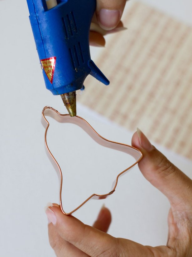 Hot Glue Gun Dabs Glue Around Edge of Copper Cookie Cutter