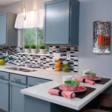 Blue Kitchen With Small Breakfast Bar and Tile Backsplash 