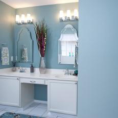Blue Bathroom With Double Vanity and Intricate Mirrors
