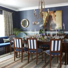 Two-Toned Blue Dining Room With Striped Chairs and Area Rug