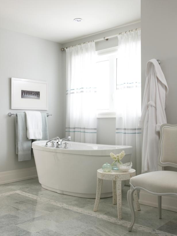 White Bathroom With Oval Freestanding Tub and Patterned Table