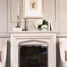 Classic Stone Fireplace With Candlesticks and Framed Art