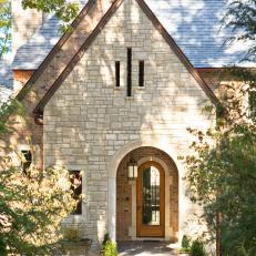 Stone Home Exterior With Arched Entry and Front Door