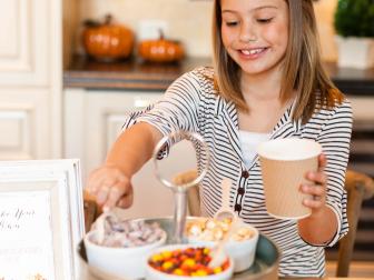 original_Kim-Stoegbauer-Thanksgiving-snack-mix-station-girl-filling-cup-crop