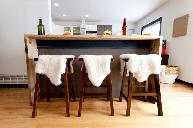 Rustic Wood Bar With White Faux Sheepskins on Wood Stools