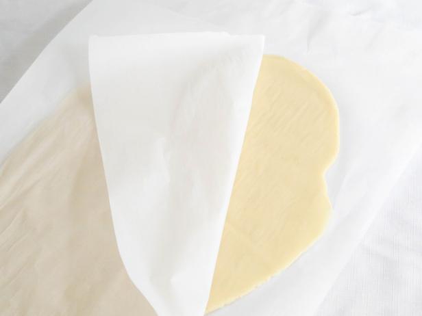 Turn the dough out onto a sheet of wax paper and top with a second sheet. Roll dough into an oblong disc between the papers with a rolling pin.
