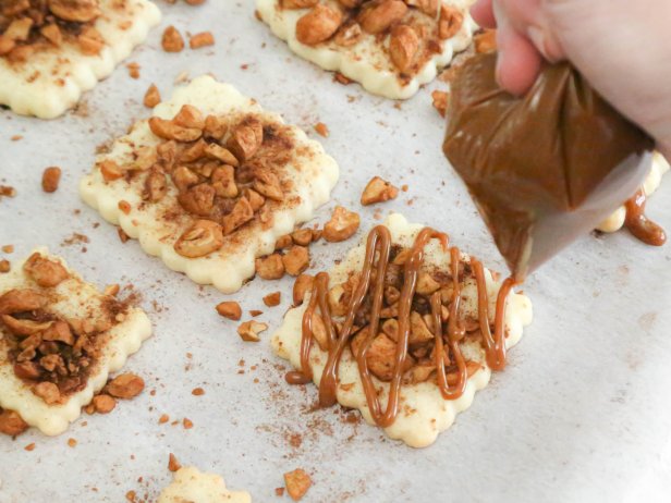 Pipe zigzag lines of dulce de leche over each cookie.