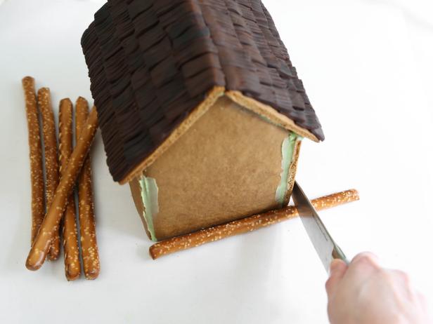 Measure pretzel rods against the front of the house and cut to size with a sharp knife.