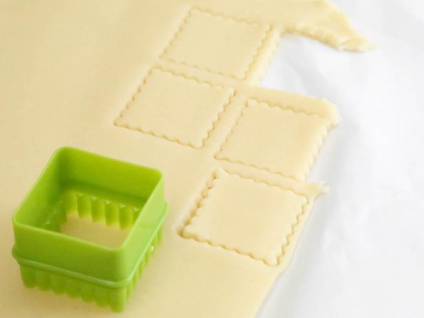 Cut dough into 3-inch squares using a cookie cutter and place on parchment-lined baking sheets.