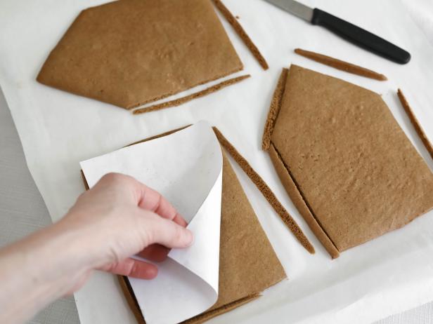 Remove the gingerbread from the oven and re-cut the pieces using the templates and a sharp knife. This will ensure the pieces fit together perfectly when assembled. Let pieces cool completely.