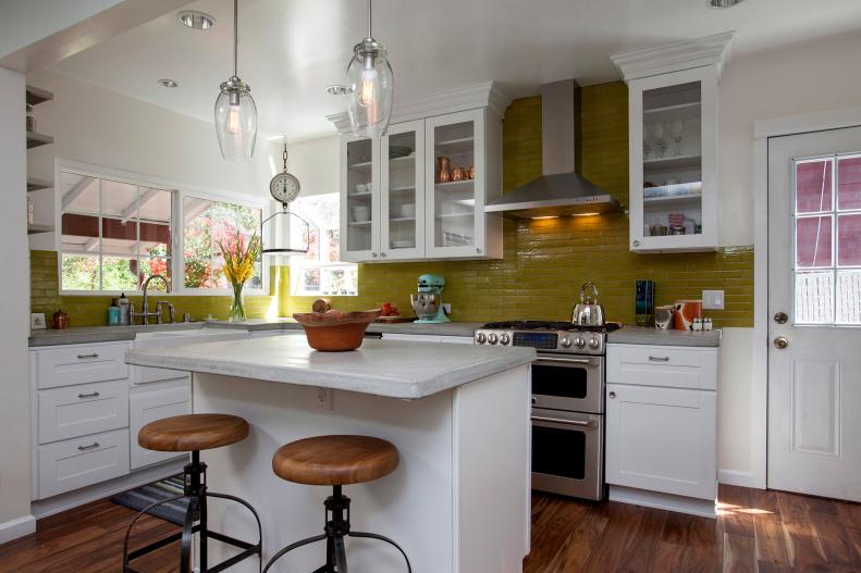 White Open Kitchen With Green Backsplash and Glass Pendants.