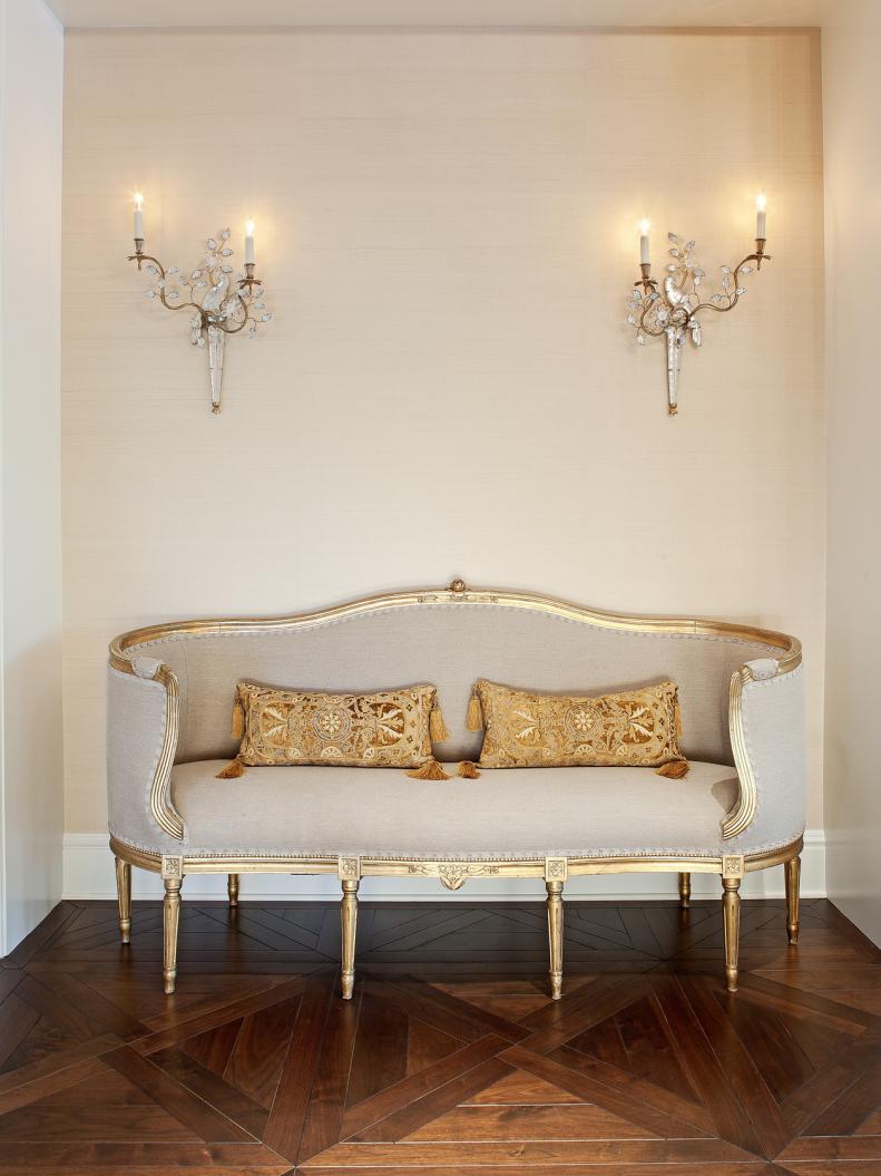French Settee Surrounded by Elegant Wall Sconces  