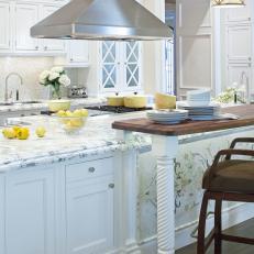 White Kitchen With Breakfast Bar and Marble Countertops