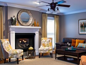 Living Room With White Fireplace Mantel, Floral Chairs and Round Mirror