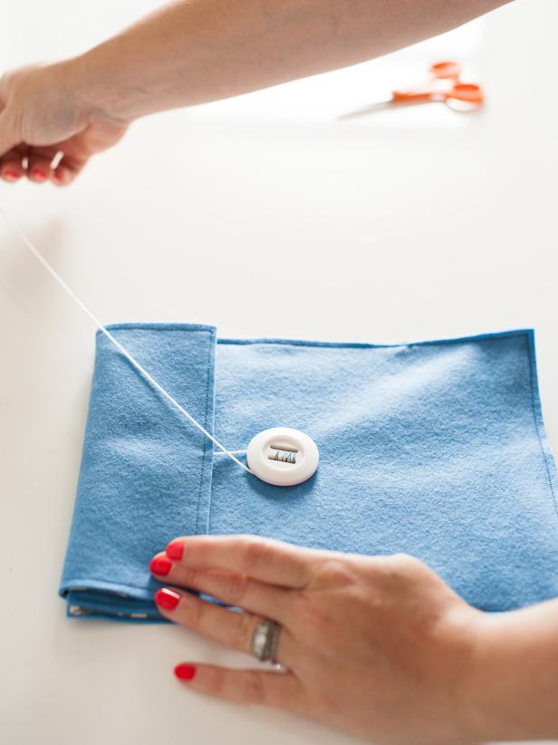 Sew a button onto your felt cover. The case closes by folding down the flap and wrapping the cording around the button.