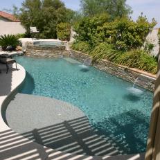 Curved Pool With Double Spillways and Raised Hot Tub
