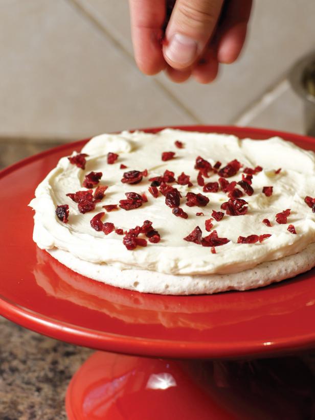 1. Place a small dab of mousse on the serving dish to hold disk in place.2. Add first meringue disk and top with 1/4 of the mousse. Top with sprinkling of dried cranberries. 3. Repeat layers of disk, mousse and cranberries until you reach the top. Add a sprinkling of sliced almonds.Note: If there will be a delay between cooled meringues and assembly, be sure to store the meringues in an airtight container. This dessert is best served right away, but could be kept in the refrigerator briefly; however, the meringues will soften.