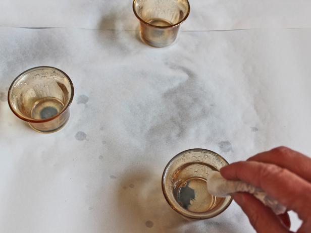 Wait five minutes for the paint to dry on the votives' sides, then carefully dab away excess water and spray paint from the bottom with a paper towel, being careful not to hit the votives' sides.