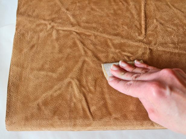 Starting with coarse-grit sandpaper (and working your way down to medium- then fine-grit), sand the leather, concentrating on any wrinkles or raised areas and the edges of the spine (Images 1 and 2). Tip: Just like distressing furniture, the key is to sand the areas that would naturally see the most wear and tear over time.