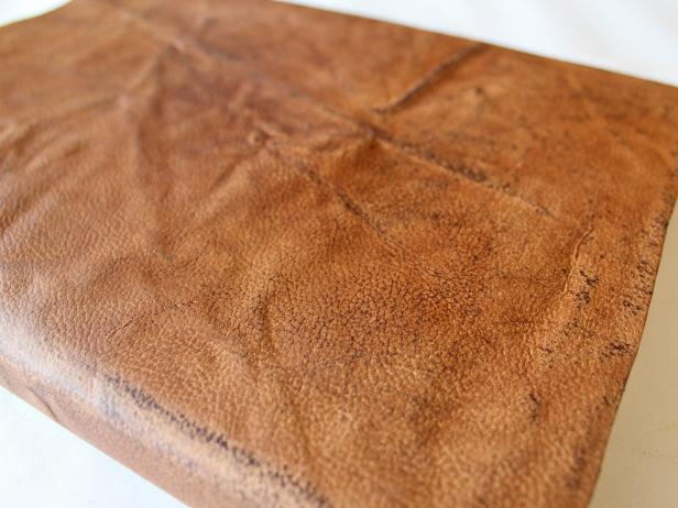 After shoe polish has dried, buff the leather for the handmade book cover with a second cloth to give it a soft sheen.