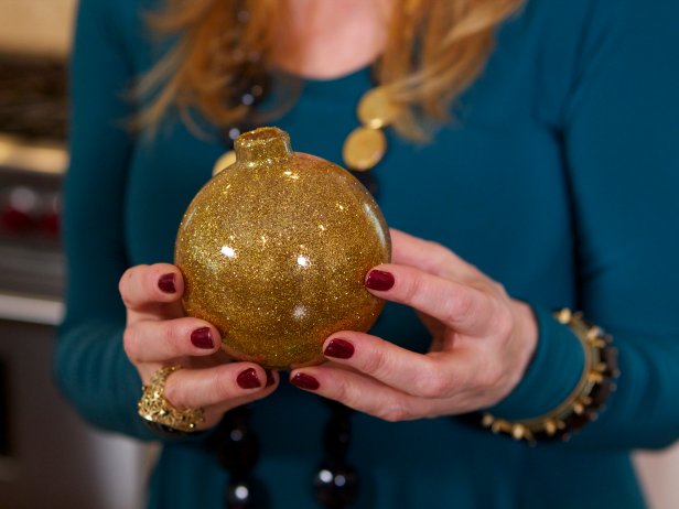 Robin Baron makes custom glitter glass Christmas ornaments. In this step, she swirls the glitter around ensuring that it bonds properly to the floor finish added previously.