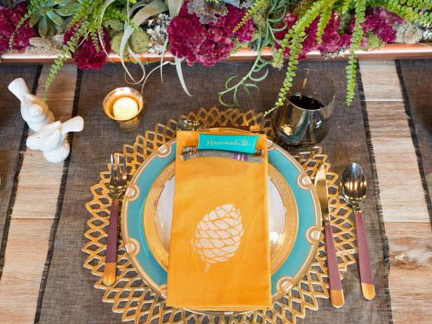 A rustic holiday place setting with hand-stamped linens, a succulent centerpiece and glass votives painted with a mercury glass finish makes for a romantic tablescape.