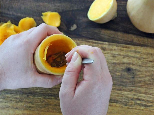 Using the spoon, hollow out the squash until you reach the seeds at the bottom. Turn the squash upside down, tapping on the cutting board until free of seeds. Repeat with remaining squash to complete step three.